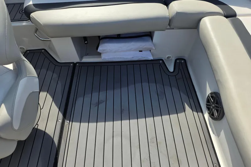 Slide: The Image of 2022 Starcraft MDX 191 E O/B boat interior with gray flooring and cushioned seating. - 19