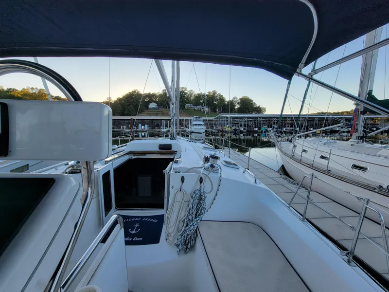 Slide: The Image of 2004 Hunter 41 AC sailboat cockpit view at marina, featuring steering wheel and seating area. - 20