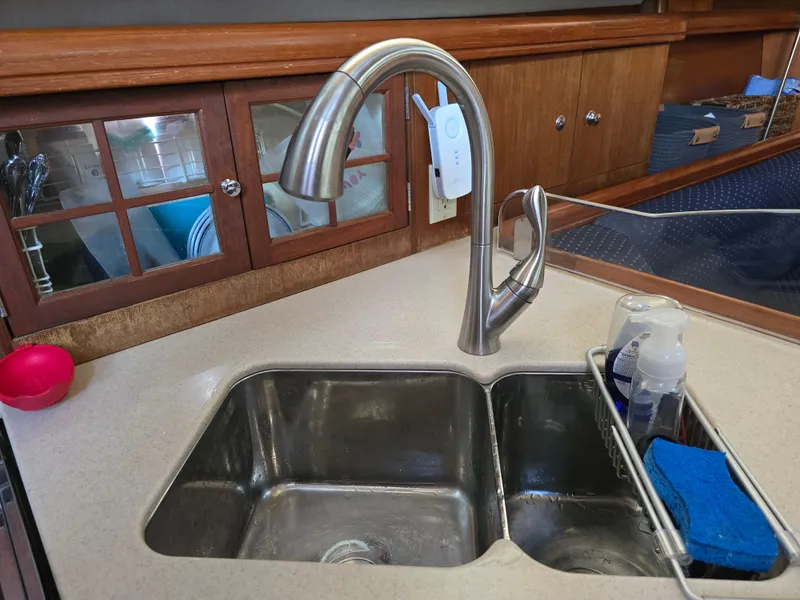 Slide: The Image of Kitchen sink with modern faucet in a 2004 Hunter 41 AC yacht interior. - 26