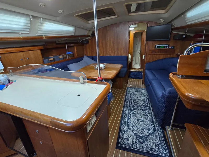 Slide: The Image of Interior of a 2004 Hunter 41 AC sailboat with wood finish and blue seating. - 27
