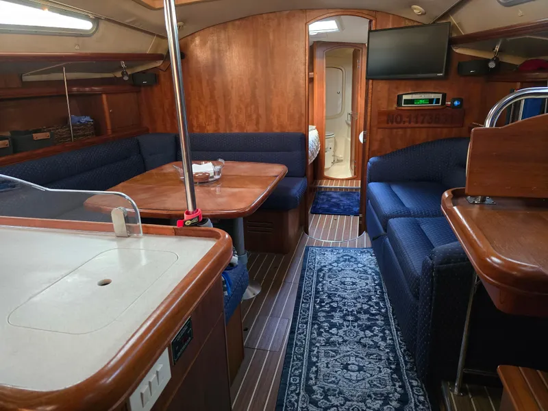 Slide: The Image of Interior of 2004 Hunter 41 AC sailboat with wood finish and blue seating. - 28