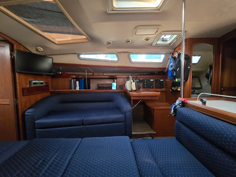 Slide: The Image of Interior of a 2004 Hunter 41 AC sailboat with blue seating and wooden accents. - 30