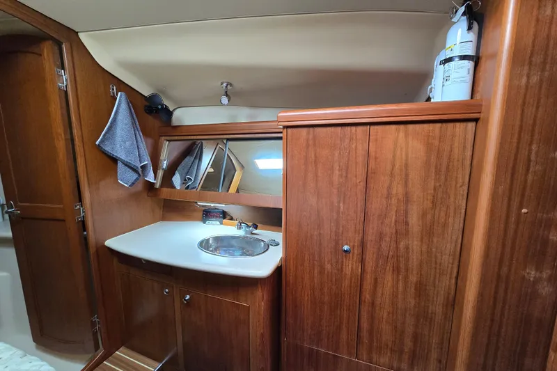 Slide: The Image of Interior of 2004 Hunter 41 AC yacht bathroom with wooden cabinetry and sink. - 34
