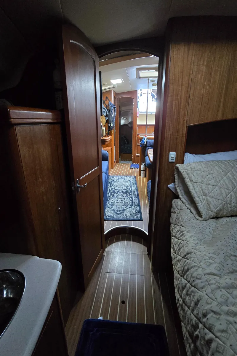 Slide: The Image of Interior of 2004 Hunter 41 AC sailboat with wood paneling and cozy bedding. - 35