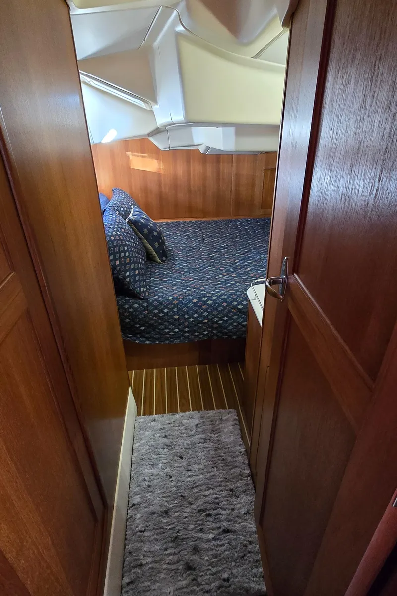 Slide: The Image of 2004 Hunter 41 AC yacht cabin with wooden interior and cozy bedding. - 40
