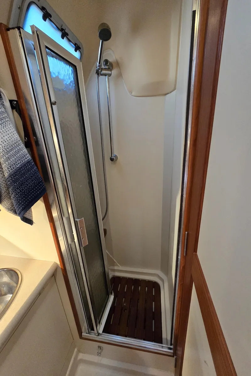 Slide: The Image of Compact shower in 2004 Hunter 41 AC sailboat with wooden floor and sliding door. - 43