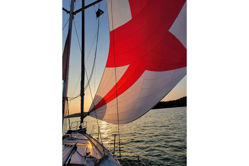 Slide: The Image of Sailing on a 2004 Hunter 41 AC yacht with vibrant red and white sails at sunset. - 6