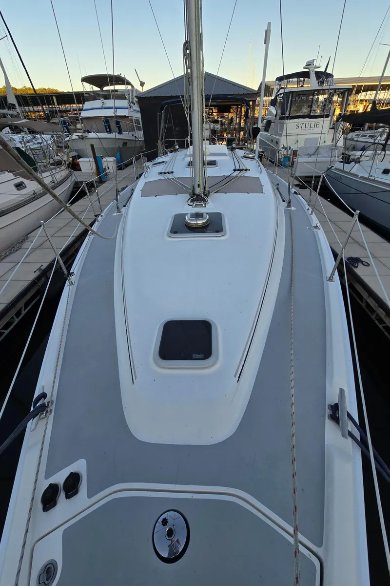 Slide: The Image of 2004 Hunter 41 AC sailboat docked at marina, showcasing sleek deck design. - 9