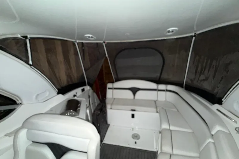 Slide: The Image of 2018 Rinker EX 320 boat interior with white seating and enclosed canopy. - 13