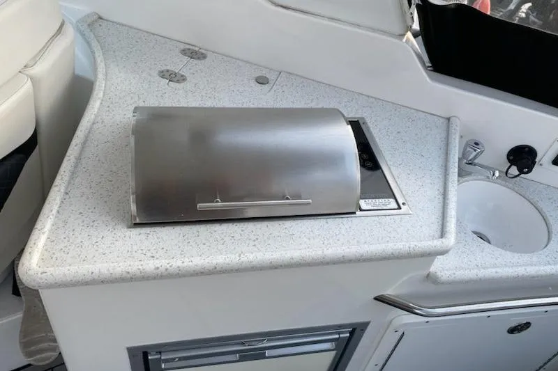 Slide: The Image of 2018 Rinker EX 320 boat kitchenette with grill and sink. - 14