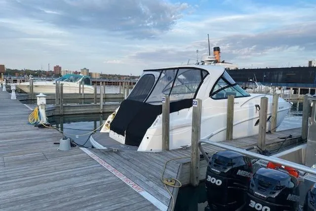 Slide: The Image of 2018 Rinker EX 320 boat docked at marina with Mercury engines. - 2