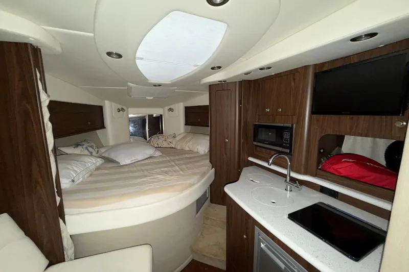 Slide: The Image of Interior of 2018 Rinker EX 320 boat with cozy bed, kitchenette, and modern amenities. - 21