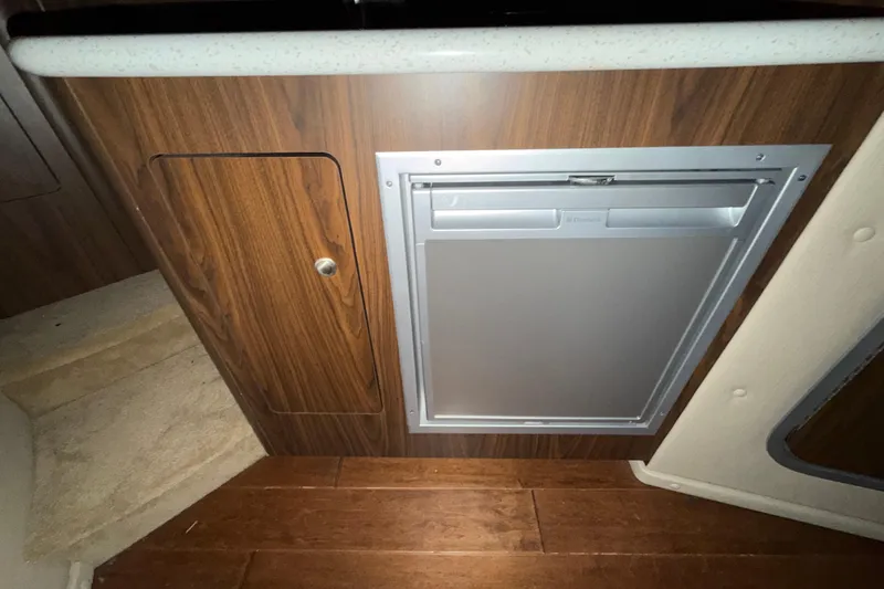 Slide: The Image of 2018 Rinker EX 320 interior with wood paneling and built-in refrigerator. - 23