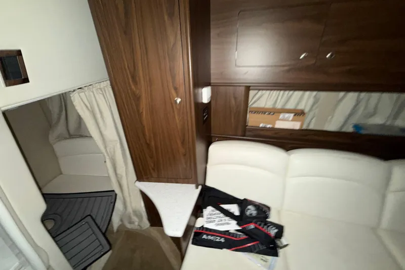 Slide: The Image of Interior of a 2018 Rinker EX 320 boat with wood cabinetry and white seating. - 24