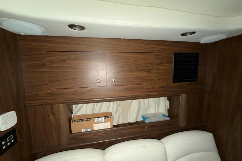 Slide: The Image of Interior of 2018 Rinker EX 320 boat with wood cabinetry and white seating. - 27