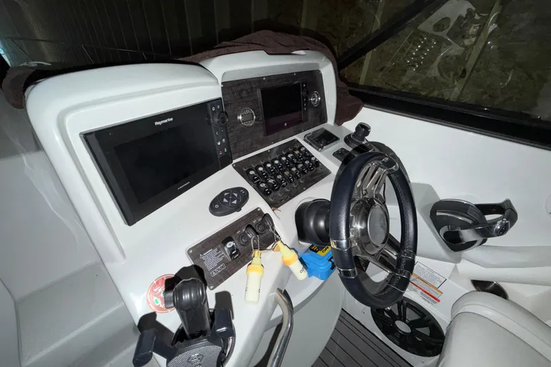 Slide: The Image of 2018 Rinker EX 320 boat dashboard with steering wheel and navigation controls. - 9