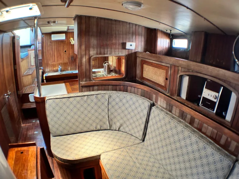 Slide: The Image of Interior of 1982 Pan Oceanic 43 sailboat with wooden paneling and patterned seating. - 17