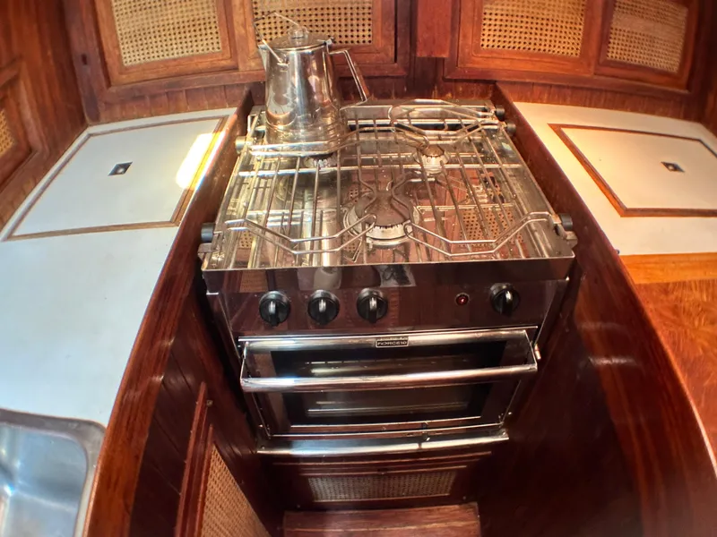 Slide: The Image of Vintage 1982 Pan Oceanic 43 yacht kitchen with stainless steel stove and wooden cabinetry. - 22