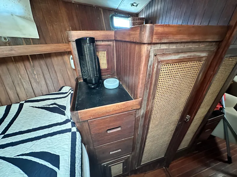 Slide: The Image of 1982 Pan Oceanic 43 yacht interior with wooden cabinetry and bed, showcasing classic nautical design. - 25
