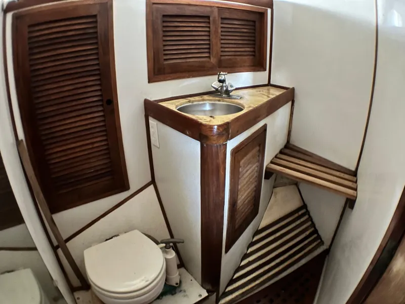 Slide: The Image of 1982 Pan Oceanic 43 yacht bathroom with wooden cabinets, sink, and toilet. - 26