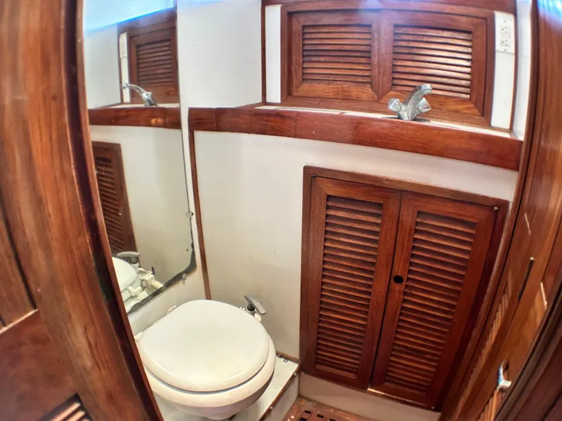 Slide: The Image of 1982 Pan Oceanic 43 yacht bathroom with wooden cabinets and a compact toilet. - 27