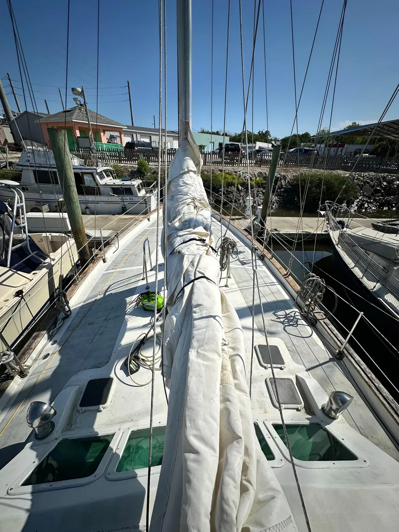 Slide: The Image of 1982 Pan Oceanic 43 sailboat docked, with mast and rigging visible under clear sky. - 3