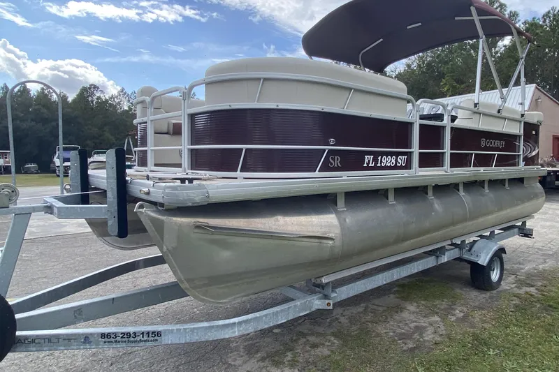 Slide: The Image of 2020 Godfrey 180 SR pontoon boat on trailer, parked outdoors under a cloudy sky. - 4
