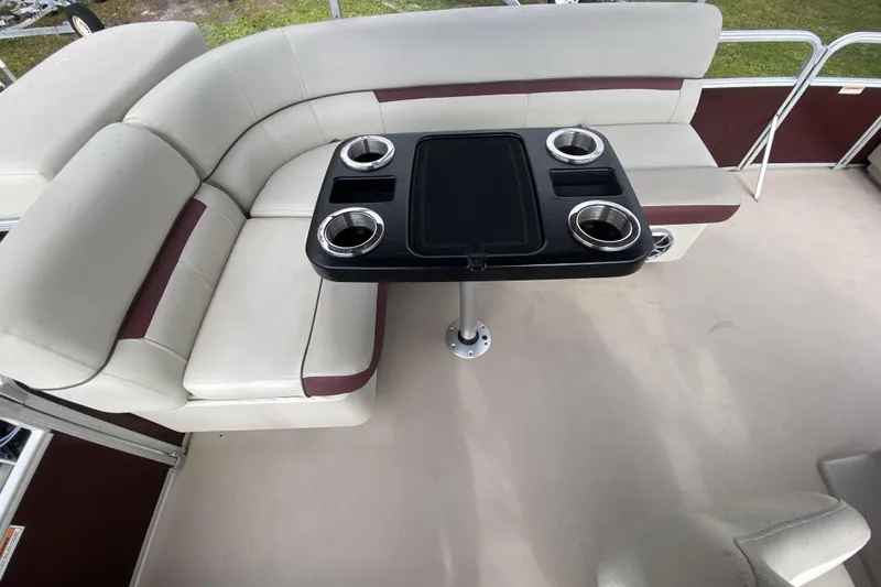 Slide: The Image of 2020 Godfrey 180 SR pontoon boat interior with cushioned seating and table with cup holders. - 8