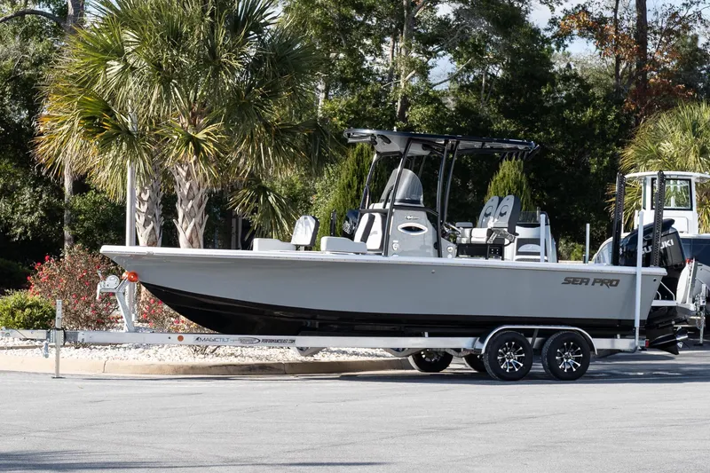 The Image of 2026 Sea Pro 250 Bay boat on trailer, parked near palm trees. - 1
