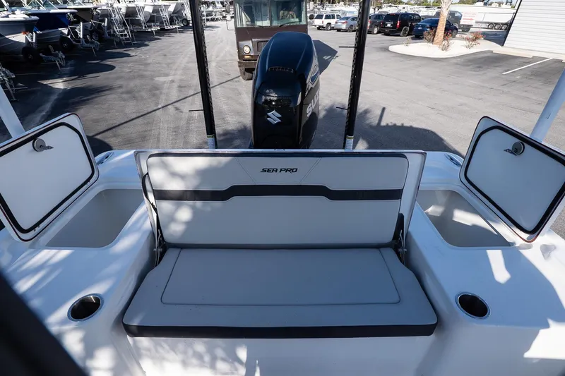 Slide: The Image of 2026 Sea Pro 250 Bay boat interior with storage compartments and Suzuki outboard motor. - 10