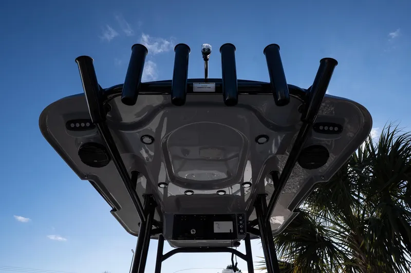 Slide: The Image of 2026 Sea Pro 250 Bay boat's underside view with rod holders against blue sky. - 13