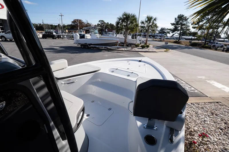 Slide: The Image of 2026 Sea Pro 250 Bay boat interior, showcasing seating and deck layout in a marina setting. - 16