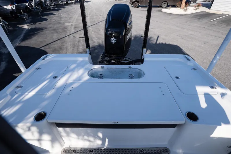 Slide: The Image of 2026 Sea Pro 250 Bay boat deck with Suzuki outboard motor in a parking lot. - 9