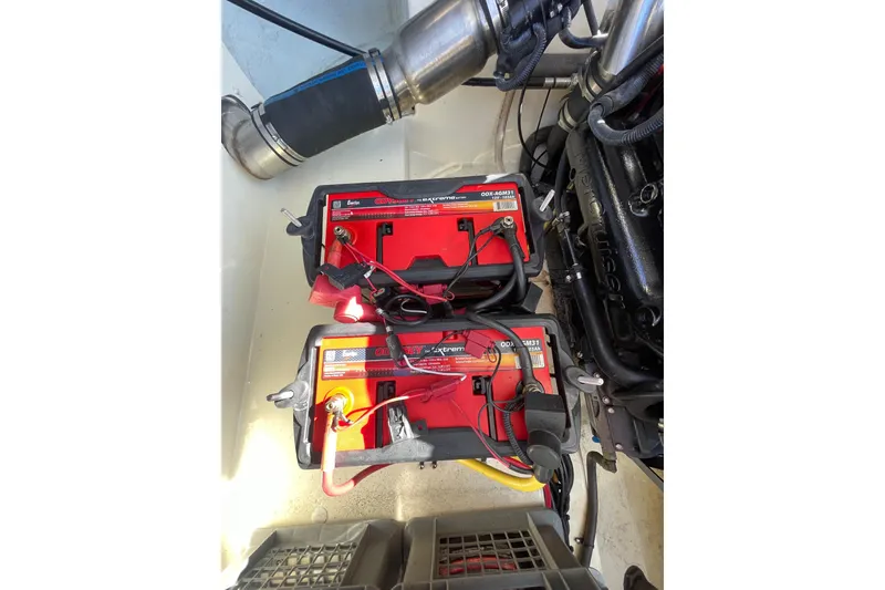 Slide: The Image of 2018 Chris-Craft Capri 27 engine compartment with two red marine batteries. - 20