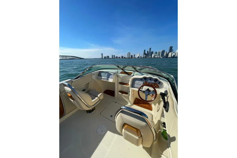 Slide: The Image of 2018 Chris-Craft Capri 27 boat interior with city skyline and bridge in background. - 3