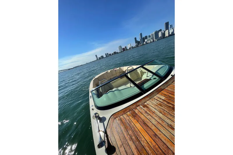 Slide: The Image of 2018 Chris-Craft Capri 27 boat on water with city skyline in background. - 5