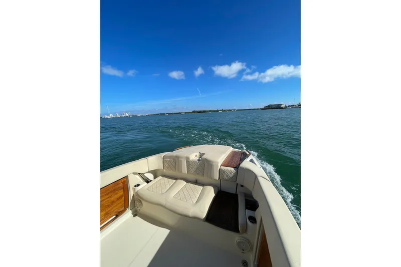 Slide: The Image of 2018 Chris-Craft Capri 27 boat cruising on open water under clear blue skies. - 8