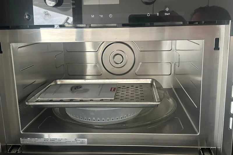 Slide: The Image of Interior of a 2020 Prestige 460 oven with a tray and manual inside. - 21