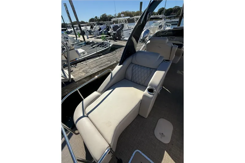 Slide: The Image of 2015 Bennington 2874 QCW boat with luxurious seating at a marina. - 11