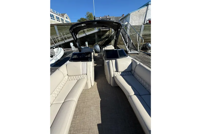 Slide: The Image of 2015 Bennington 2874 QCW pontoon boat with luxurious seating and sleek design at dock. - 5