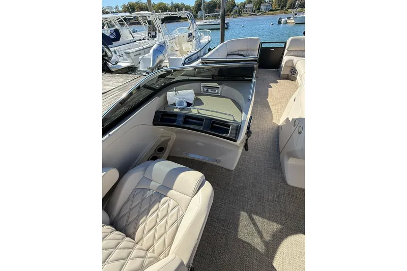 Slide: The Image of 2015 Bennington 2874 QCW boat interior with luxurious seating and waterfront view. - 7