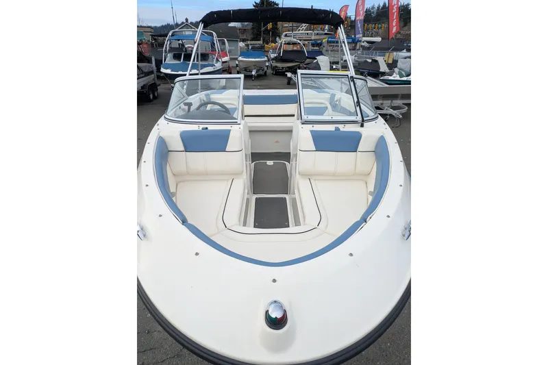Slide: The Image of 2013 Bayliner 185 Bowrider boat with open bow seating, parked outdoors. - 15
