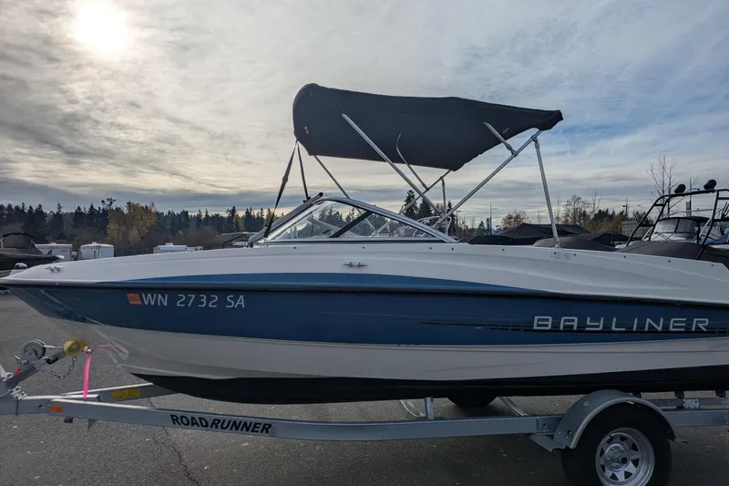 Slide: The Image of 2013 Bayliner 185 Bowrider boat on trailer under cloudy sky. - 4