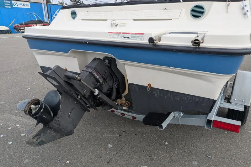 Slide: The Image of 2013 Bayliner 185 Bowrider boat on trailer, showcasing rear view and motor. - 6