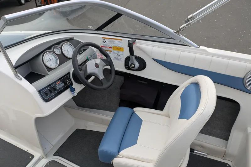 Slide: The Image of 2013 Bayliner 185 Bowrider cockpit with steering wheel, gauges, and blue-white seating. - 8