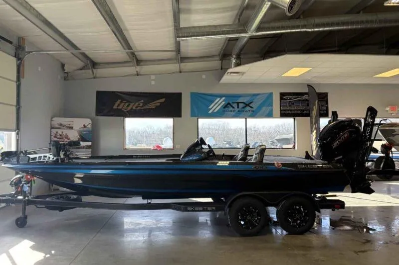 The Image of 2026 Skeeter ZXE21 boat in showroom, side view with banners in background. - 0