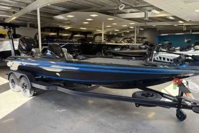 Slide: The Image of 2026 Skeeter ZXE21 boat in showroom, featuring sleek design and dual-axle trailer. - 3