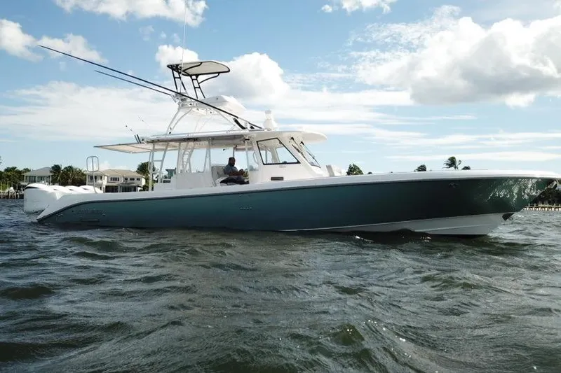 Slide: The Image of 2016 Everglades 435 Center Console boat cruising on open water under a cloudy sky. - 1