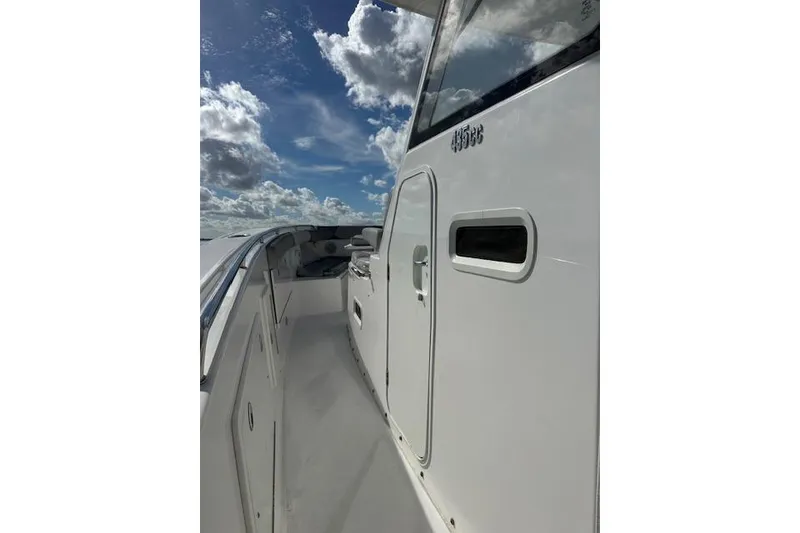 Slide: The Image of 2016 Everglades 435 Center Console boat under a partly cloudy sky. - 13