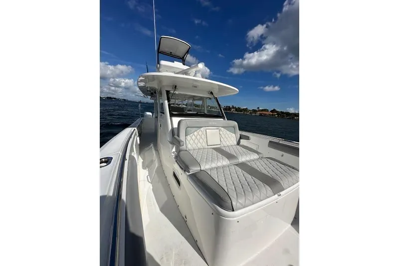 Slide: The Image of 2016 Everglades 435 Center Console boat on water, featuring sleek design and cushioned seating. - 17